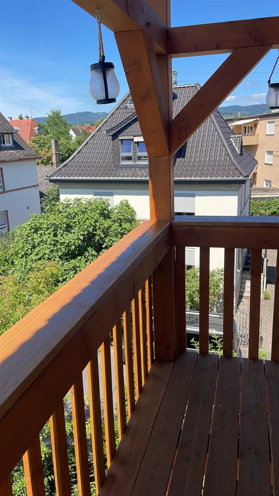 Balkon mit Holzgeländer und Dielenboden im Abendlicht