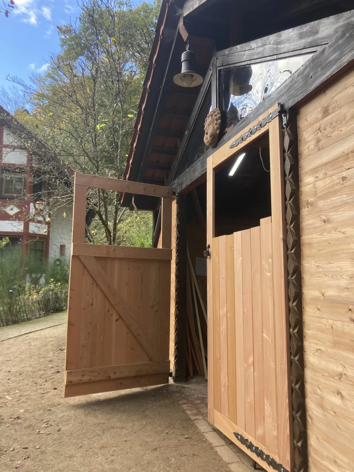Geöffnetes Carport-Tor aus Douglasie mit geschmiedeten Bändern