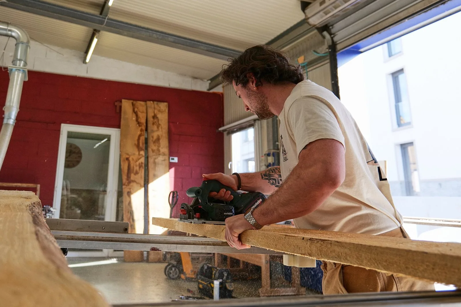 Zimmermann bearbeitet einen Holzbalken mit dem Elektrohobel