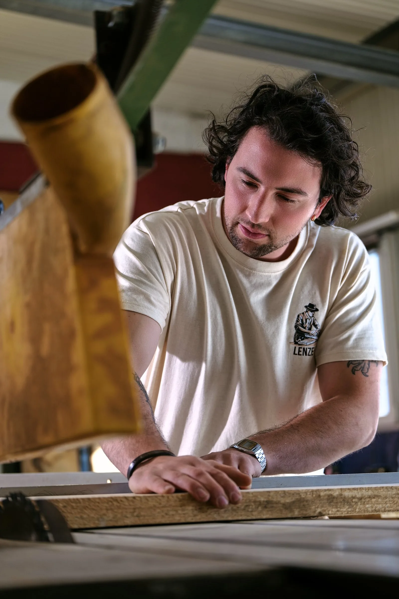 Francisco arbeitet konzentriert an einem Holzwerkstück in der Werkstatt