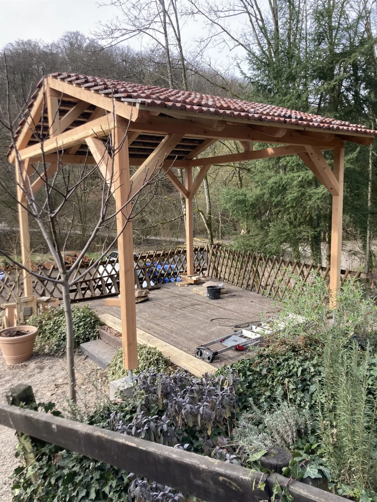 Fertiger Pavillon mit Altziegeldach über der Holzterrasse