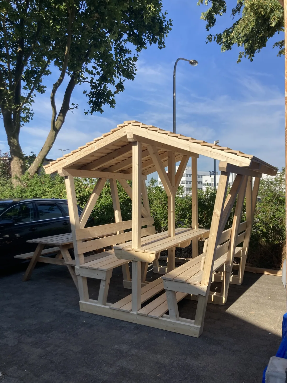Überdachte Sitzhütte aus Holz mit Tisch und Bänken