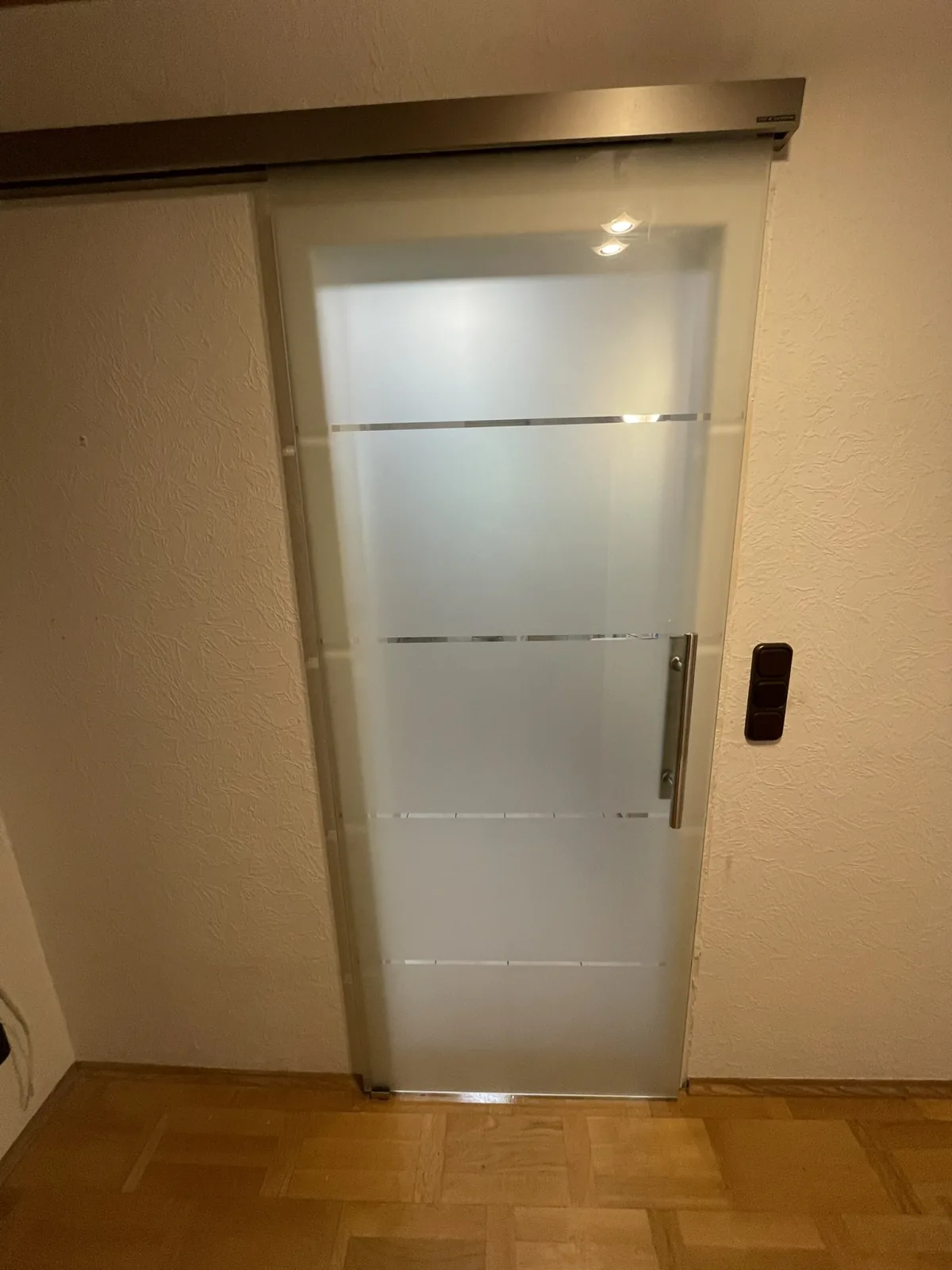 Glasschiebetür mit Milchglas und Edelstahl-Laufschiene