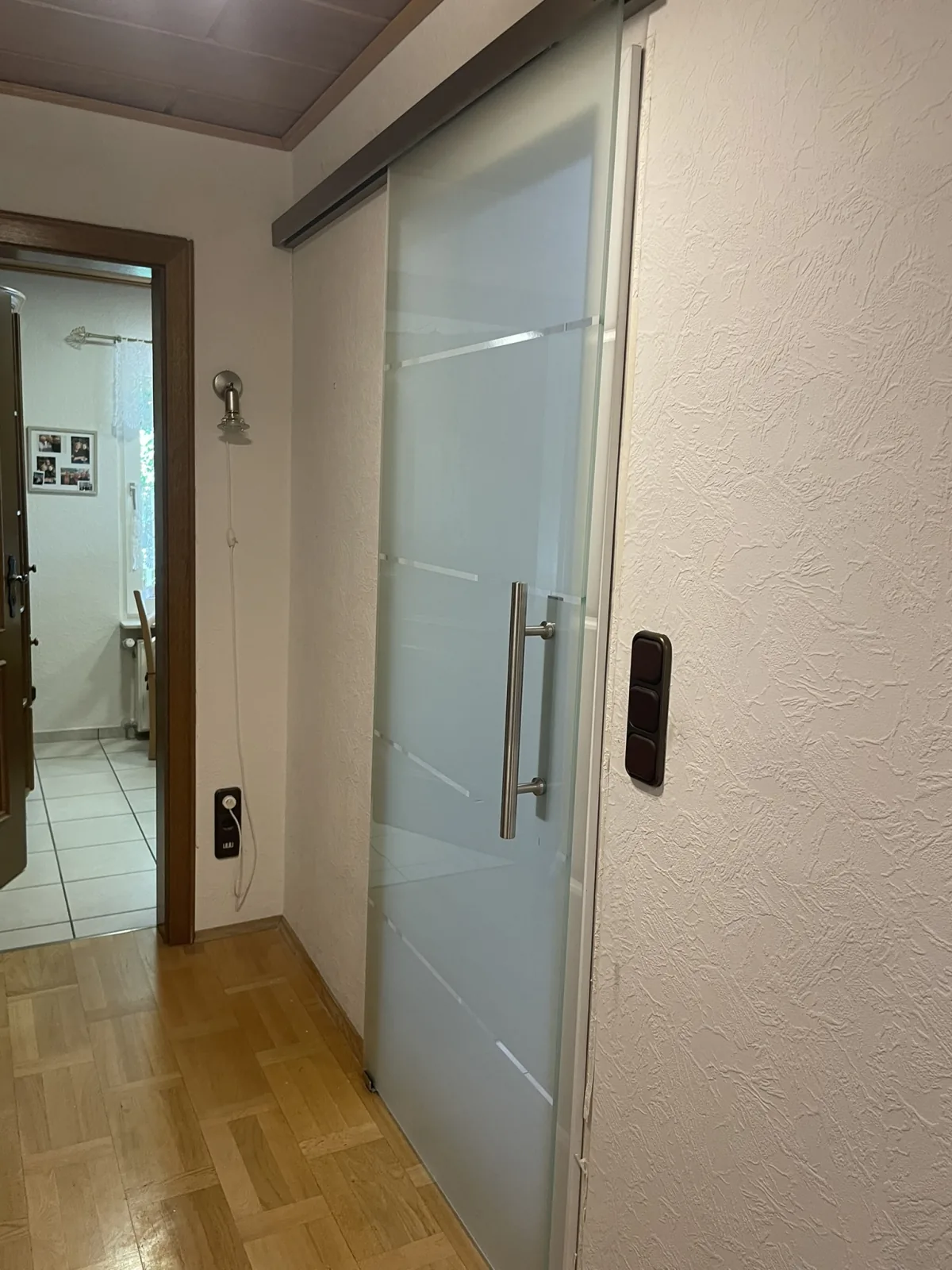 Glasschiebetür im Wohnbereich mit Parkettboden